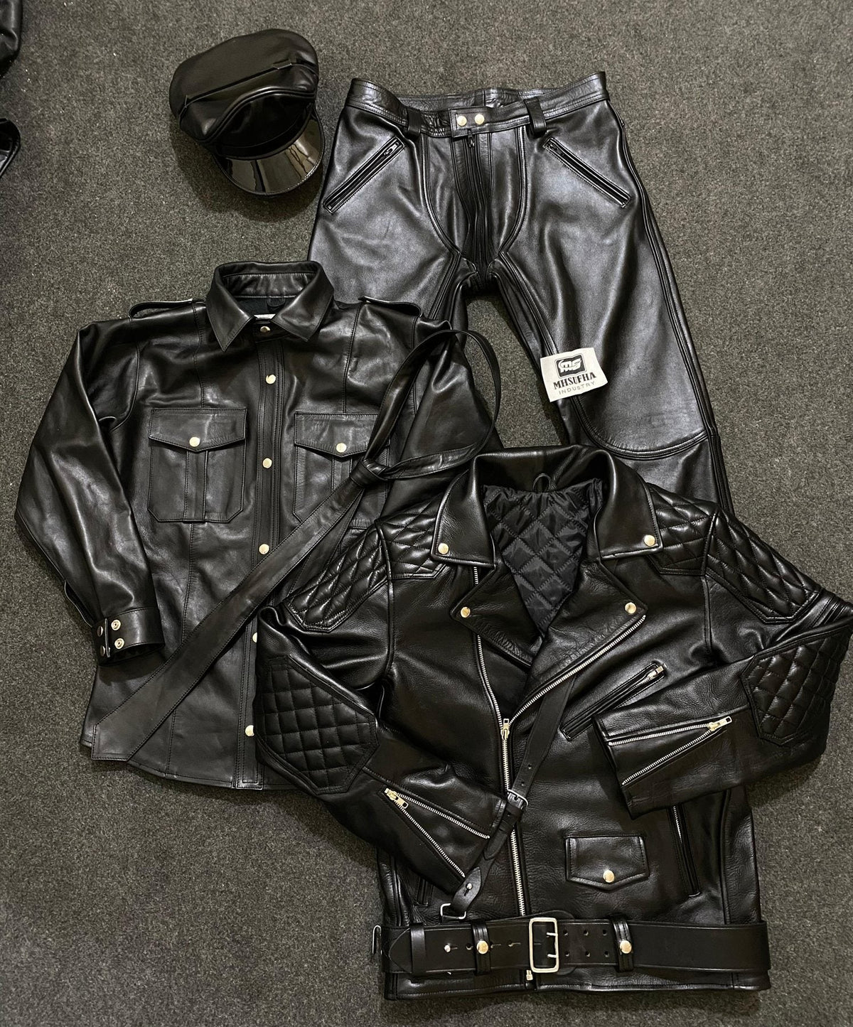 Black leather bundle - quilted jacket, uniform shirt, trousers, peaked cap and tie laid flat